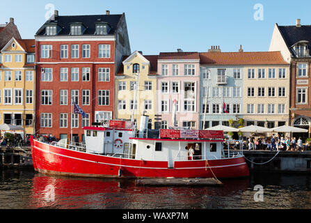Nyhavn Copenhagen DANIMARCA - gli edifici colorati e barca in estate il sole in agosto, Nyhavn waterfront, Copenhagen DANIMARCA Scandinavia Europa Foto Stock