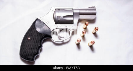 Un acciaio inossidabile, naso camuso 357 revolver Magnum con cinque Full Metal Jacket proiettili accanto ad essa su sfondo bianco Foto Stock
