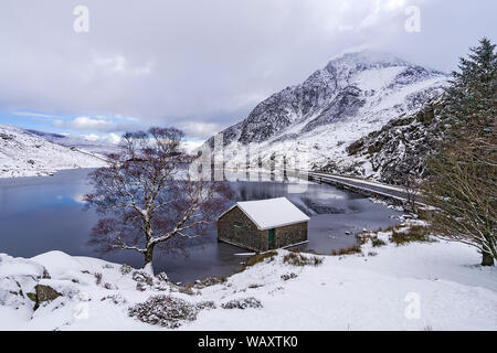 Llyn Ogwen in inverno guardando ad est che mostra il boathouse con l'A5 road e monte Tryfan di destra sul Parco Nazionale di Snowdonia North Wales UK Febbraio 2018 Foto Stock