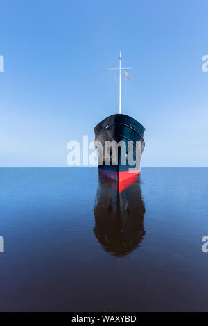 Vista frontale della prua di un oceano andando liner / nave su un tranquillo e calmo mare vuota con un lontano orizzonte e cielo blu chiaro con nessuno in vista, Foto Stock