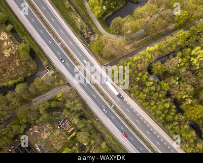 Vista aerea di quattro lane motorway con corsia di emergenza e traffico moderato durante le ore di punta Foto Stock