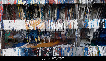 Scartato barattoli di vernice fare immagini astratte al porto, a MacDuff, Aberdeenshire, Scotland, Regno Unito Foto Stock
