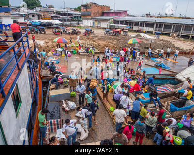 Iquitos, Perù - 14 Maggio 2016: una folla di persone locali su un bordo nave da carico e una costa fangoso di una porta attraverso il fiume del Amazon in Iguitos. Amazonia. S Foto Stock