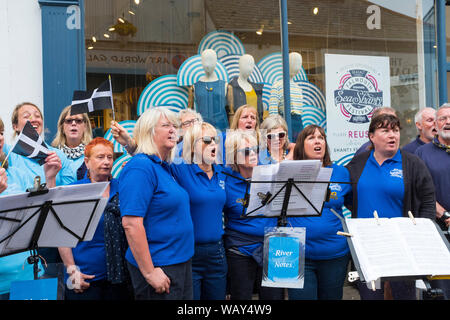 Il fiume note coro coro cantando in strada a Falmouth, Cornwall durante il mare annuale Shanty Festival, England, Regno Unito Foto Stock