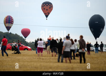 Jindrichuv Hradec, Repubblica Ceca. Il 22 agosto, 2019. I palloni ad aria calda volare durante il 23° FAI Mongolfiera campionato ceco in Jindrichuv Hradec nella Repubblica Ceca. Venti cinque candidati provenienti da undici paesi partecipano all'evento. La serata inizia nei pressi di Jindrichuv Hradec city (136 chilometri a sud di Praga). Gli spettatori a guardare la sera inizio palloncini. Credito: Slavek Ruta/ZUMA filo/Alamy Live News Foto Stock