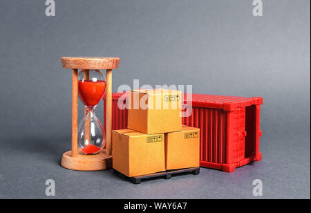 Contenitore rosso con scatole di cartone e una clessidra. Express consegna in breve tempo concetto. La memorizzazione temporanea e limitata e convenienti. Optimizati Foto Stock