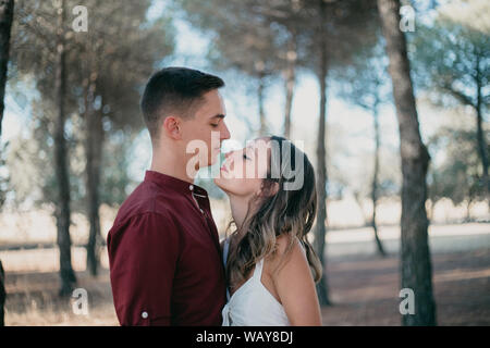 Uomo di fronte a una donna che abbraccia in una foresta Foto Stock