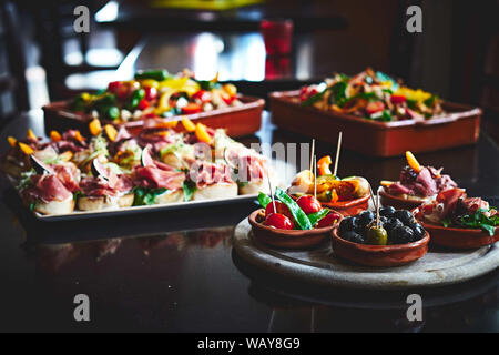 Varie Tapas-Cups, insalate e pane morsi su un tavolo in un Bar di tapas Foto Stock