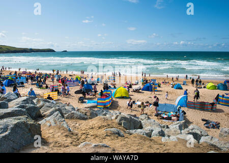 I turisti in vacanza in vacanza su una soleggiata spiaggia Fistral a Newquay in Cornovaglia. Foto Stock