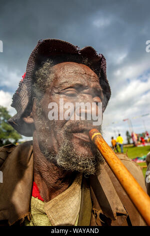 L'uomo fuma tubazione tradizionali nel mercato a Chencha sud Etiopia Foto Stock