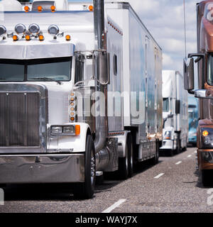 Convoglio di diverse marche e modelli professionali di grado industriale long haul big rig semi carrelli con semirimorchi in esecuzione su vasta multiline hig Foto Stock