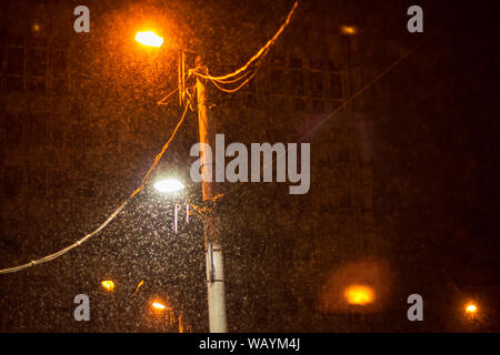 Street lampade di illuminazione e di neve caduta nella notte Foto Stock
