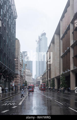 Una pioggia inzuppato street su una cortina di nubi e giornata uggiosa nella City di Londra, Regno Unito Foto Stock