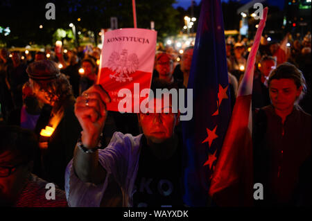 Una donna trattiene una copia della Costituzione polacca, un UE e bandiera polacca davanti a Cracovia la corte durante una manifestazione di protesta contro i maltrattamenti di giudici selezionati da un funzionario del Ministero della Giustizia.Il 19 agosto, polacco news sito onet.pl, ha pubblicato una relazione sostenendo che il Vice Ministro della giustizia Lukasz Piebiak "disposti e comandati" una campagna online contro la testa di Iustitia, una organizzazione giudiziaria sfavorevole per le riforme del governo del sistema giudiziario. Lo stesso giorno, il Vice Ministro della giustizia Lukasz Piebiak dimesso dalla sua posizione in il conservatore del partito un diritto Foto Stock