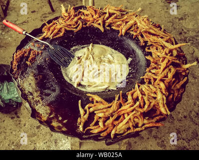 La cottura di cibo di strada fritos Charales essendo fritti su un comal in un piccolo villaggio di Michoacan Messico Foto Stock