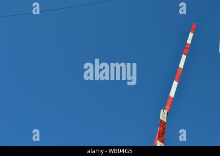 Ampio scatto di una barriera automatica rossa e bianca Foto Stock