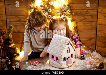 Dei bambini felici con natale panpepato in una sala decorata di vacanza. Foto Stock