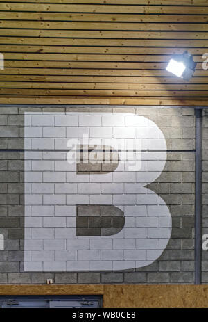 Lettera grande dipinto sul mattone parete hall per devide camera per sezioni più piccole. Foto Stock