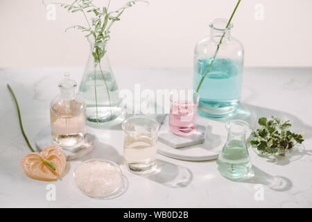 Composizione con oli essenziali e fiori sul tavolo Foto Stock