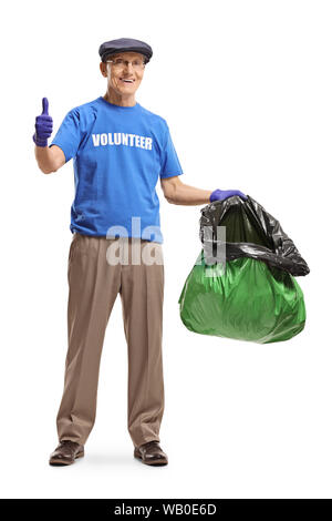 A piena lunghezza Ritratto di un anziano volontario tenendo un sacco dei rifiuti di plastica e mostrando pollice in alto isolato su sfondo bianco Foto Stock