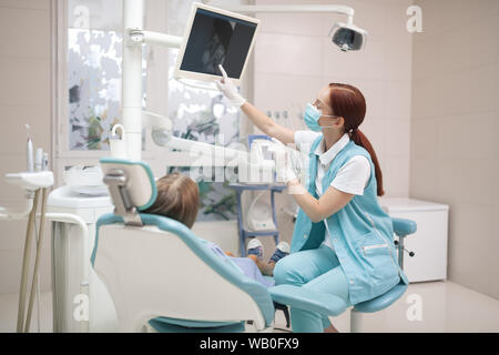 Ragazza guardando lo schermo mentre il dentista fare raggi X Foto Stock