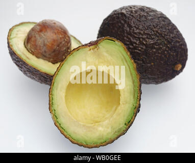 Ripe Avocado Haas. Frutto di Avocado intero e tagliato a metà su sfondo bianco Foto Stock