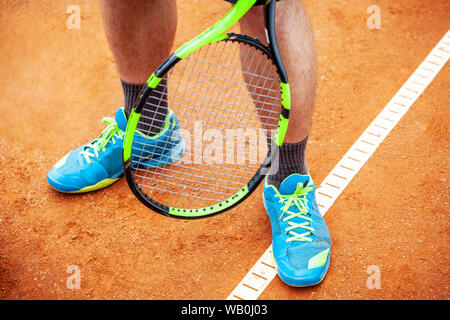 Tennista gambe in scarpe da tennis in piedi su un clay court close up. Foto Stock