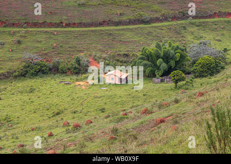 Piccolo e isolato agriturismo nel mezzo del campo verde e colline, Minas Gerais, Brasile Foto Stock