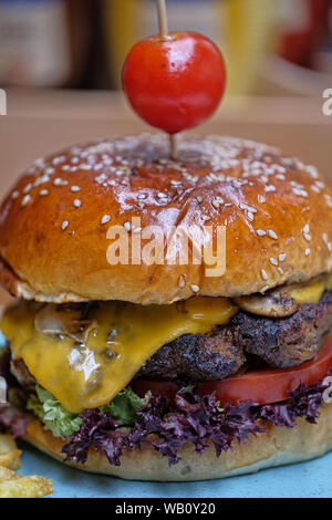 Il Fast Food, Hamburger. Speciali preparati di carne di vitello hamburger, patatine fritte e doppio formaggio cheddar. Close-up delizioso dolce gustoso hamburger fatti in casa. Foto Stock
