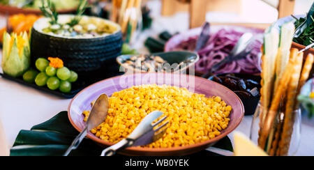 Chiusura del tavolo pieno di alimenti come verdure e più ma con nessuno prendendo il cibo della tavola - Pronto per il pranzo di cena Foto Stock