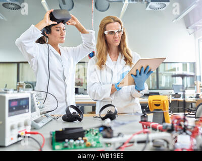 Femmina di tecnici che lavorano con la compressa e occhiali vr Foto Stock