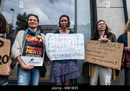 Monaco di Baviera, Germania. 23 Ago, 2019. Rispondendo a rivendicazioni da parte di al Presidente del Brasile Bolsonaro che le ONG possono avere impostato gli incendi che attualmente infuria attraverso l'Amazzonia, attivisti dalla ribellione di estinzione e quindi il venerdì per il futuro si sono riuniti di fronte all'ambasciata brasiliana a Monaco di Baviera, Germania utilizzando una filiera in centinaia di grandi per portare attenzione alla distruzione della più grande del mondo di anidride carbonica repository attualmente in corso. Credito: ZUMA Press, Inc./Alamy Live News Foto Stock