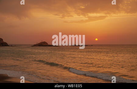 Il tramonto sotto il bel cielo azzurro sulla spiaggia Foto Stock