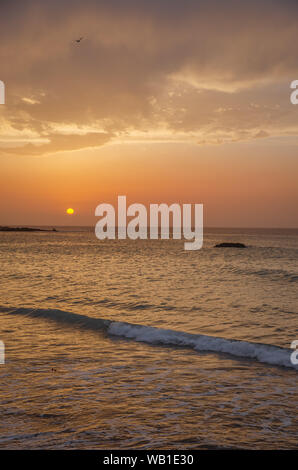 Il tramonto sotto il bel cielo azzurro sulla spiaggia Foto Stock