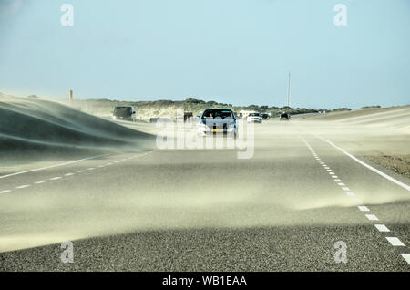 Brouwersdam, Paesi Bassi, 10 agosto 2019: un forte vento in un giorno di estate soffia la sabbia dalla spiaggia e dalle dune sulla strada Foto Stock