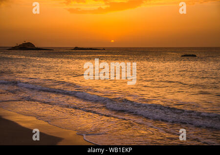 Il tramonto sotto il bel cielo azzurro sulla spiaggia Foto Stock