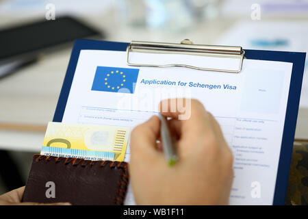 Maschio di tenere in mano la penna in argento con Passport Foto Stock