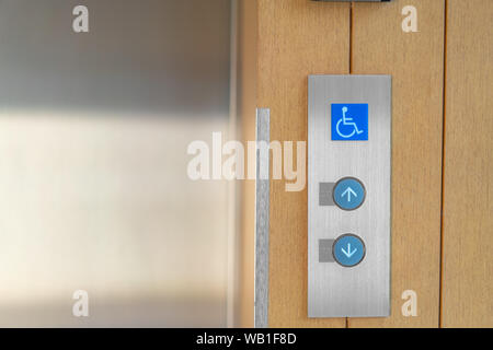 Ascensore pulsanti con i codici Braille e segno di handicap. Consentire indicazioni per verso l'alto e verso il basso. Foto Stock