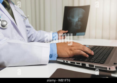 Medico di diagnosticare e analizzare su una pellicola a raggi x del paziente. Foto Stock