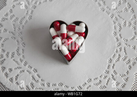 A forma di cuore pieno di pillole Foto Stock