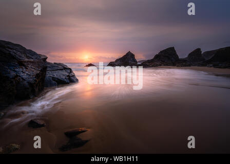 Tramonto al bellissimo Bedruthan Steps in North Cornwall, con il profilarsi di pile di mare. Foto Stock