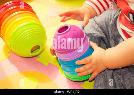 Bambini che giocano con colorate piramide giocattolo Foto Stock