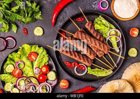 Tradizionali del medio oriente arabo o mediterranea spiedini di carne con verdure e pane pita. Vista dall'alto. Foto Stock