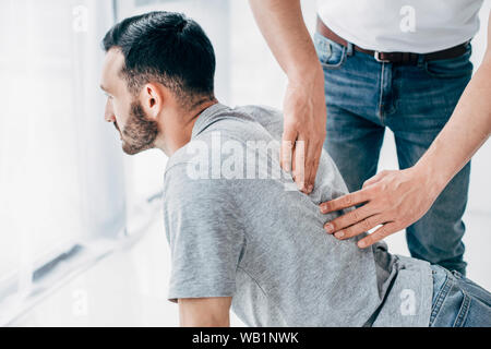 Massaggio chiropratico di retro di uomo barbuto in ospedale Foto Stock