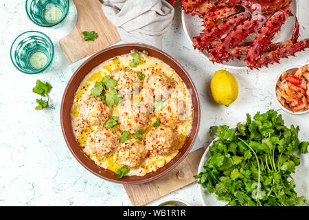 CRABMEATBALLS polpette di granchio in bianco salsa cremosa di colore rosso di pan, tutto il granchio reale, il coriandolo, succo di limone e vino bianco su sfondo bianco Foto Stock