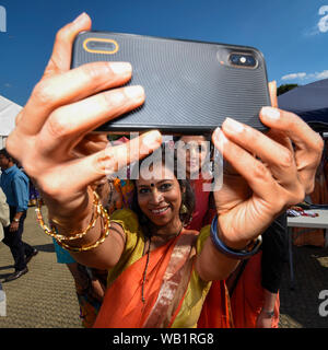 Watford, Regno Unito. Il 23 agosto 2019. I devoti prendere un selfie per festeggiare la nascita di Krishna al Janmashtami festival al Bhaktivedanta Manor Hare Krishna Temple a Watford, Hertfordshire. Il maniero fu donato al Hare Krishna movimento da ex Beatle George Harrison e ospita ogni anno il più grande festival Janmashtami al di fuori dell India. Credito: Stephen Chung / Alamy Live News Foto Stock