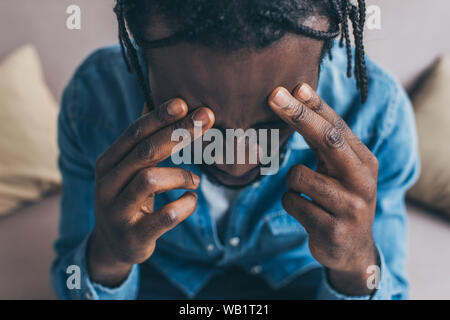 Vista aerea del african american man mano vicino a testa mentre affetti da mal di testa Foto Stock