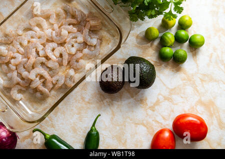 Ceviche, noto anche come cebiche, seviche sebiche e. Rendendo shrimp ceviche e gli ingredienti necessari per cucinare questo Latin American piatto di frutti di mare Foto Stock