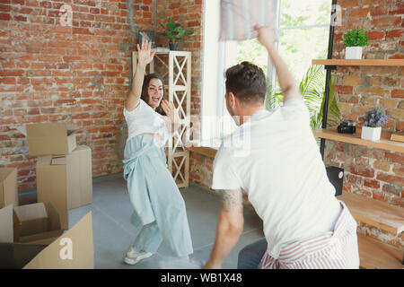 La felicità. Coppia giovane spostato in una nuova casa o appartamento. Felici e sicuri. Famiglia, spostamento, relazioni, prima home concetto. Divertitevi, laughting e balli durante il disimballaggio loro scatole. Foto Stock