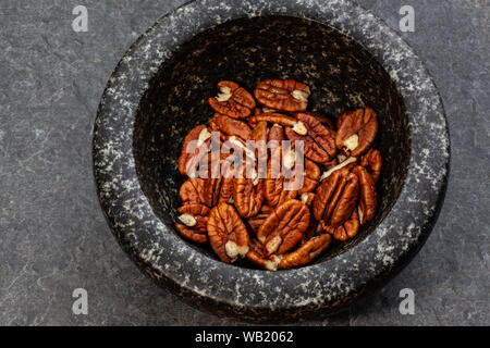 Noci pekan in pietra nera peel Foto Stock